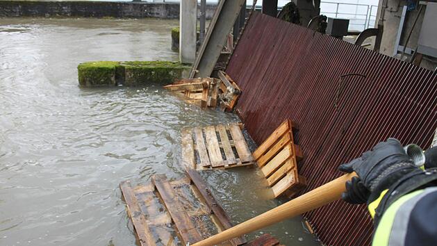 Infiana-Mitarbeiter fischen die angesp&uuml;lten Paletten in der Stra&szlig;e "Am Gr&uuml;ndelbach" aus der Wiesent.  Foto: Andreas Schmitt