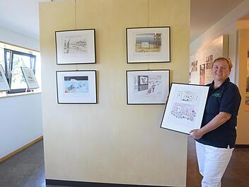 Carmen Zinsler-Maul vom Team des Bruder-Franz-Hauses präsentiert die neue Sonderausstellung "Glänzende Aussichten", die bis 28. August mit humoristischen Karikaturen Mut und Hoffnung machen will. Foto: Marion Eckert
