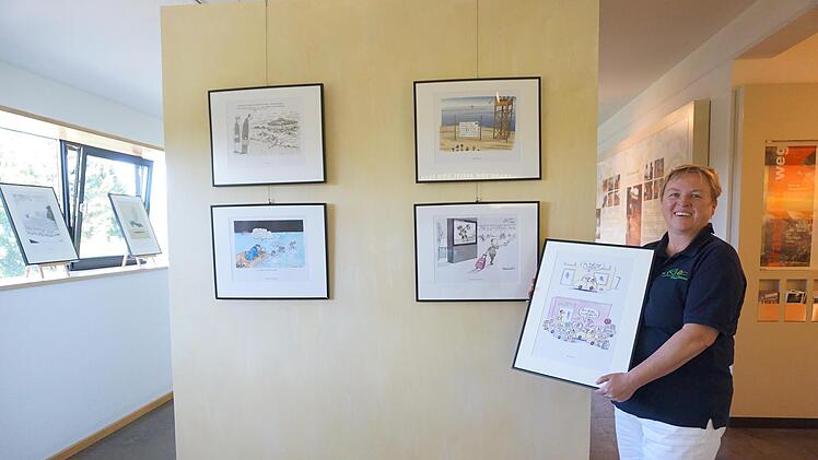 Carmen Zinsler-Maul vom Team des Bruder-Franz-Hauses präsentiert die neue Sonderausstellung "Glänzende Aussichten", die bis 28. August mit humoristischen Karikaturen Mut und Hoffnung machen will. Foto: Marion Eckert