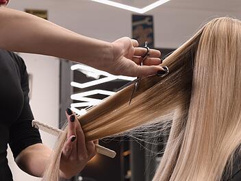 Eine Friseurin schneidet einer Frau in einem Friseursalon die Haare