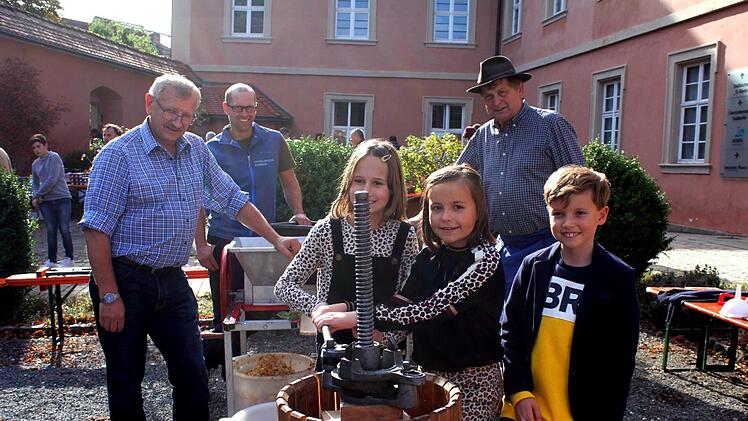 Nele Mona und Laurenz produzieren unter dem wachsamen Auge der Mitarbeiter der Umweltstation wohlschmeckenden Apfelsaft.