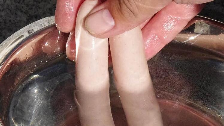 Wenn man die Bratwürste durch ein Wasserbad zieht, kleben sie nicht so schnell am Rost fest. Foto: Dominic Meißner