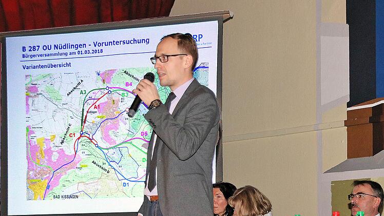 Oberbaurat Alexander Schlegel erklärt die unterschiedlichen Varianten für eine Umgebung um Nüdlingen bei der Bürgerversammlung in der Schulturnhalle  Foto: Dieter Britz