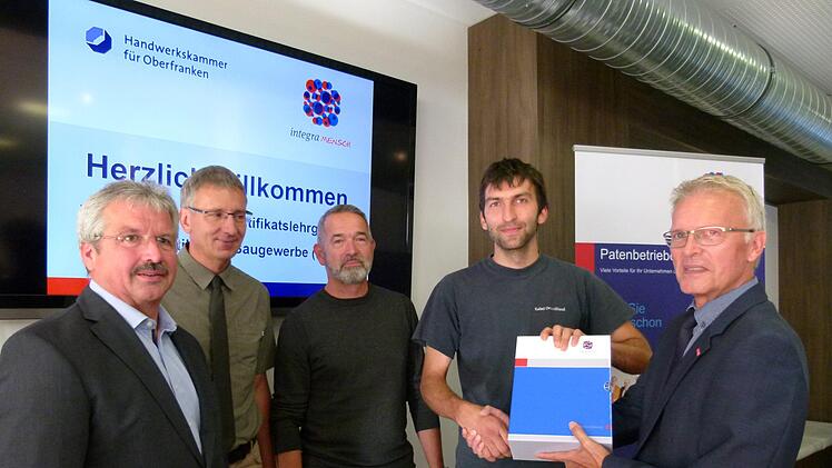 Christian und sein Chef Dieter Roy nehmen die Lehrbücher entgegen. Links Kreishandwerksmeister Manfred Amon, Kuno Eichner und rechts HWK-Hauptabteilungsleiter Peter Schirmer.