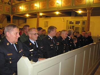 Kreisbrandrat Manfred Lorenz (vorne links) und andere Feuerwehrleute verfolgen andächtig den Jahresgottesdienst der Notfallseelsorge in der Heilig-Kreuz-Kirche. Foto: Martin Koch