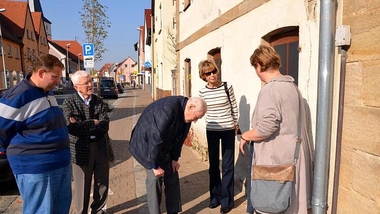 Die Kreisheimatpflegerin zeigt den Gästen die drei Stolpersteine für die jüdische Familie Kahn, die im 3. Reich ermordet wurde.