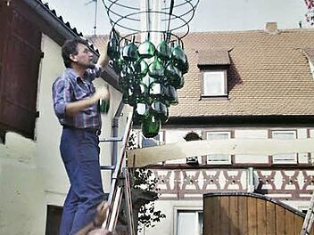 Eine Szene von den Anfängen: Karlo Weiß (auf der Leiter), Horst Hartmann (rechts) und weitere Helfer haben vor 30 Jahren in einem Hof den Riesen-Träubel aus Bocksbeutel-Flaschen aufgehängt. Eine enorme Arbeit. Heute gibt es diese Trauben allerdings nicht mehr.  Foto: Fotoclub Zeil