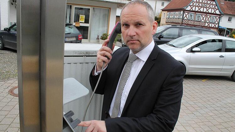Bürgermeister Jürgen Partheymüller steht am letzten öffentlichen Telefon im Marktgraitz.