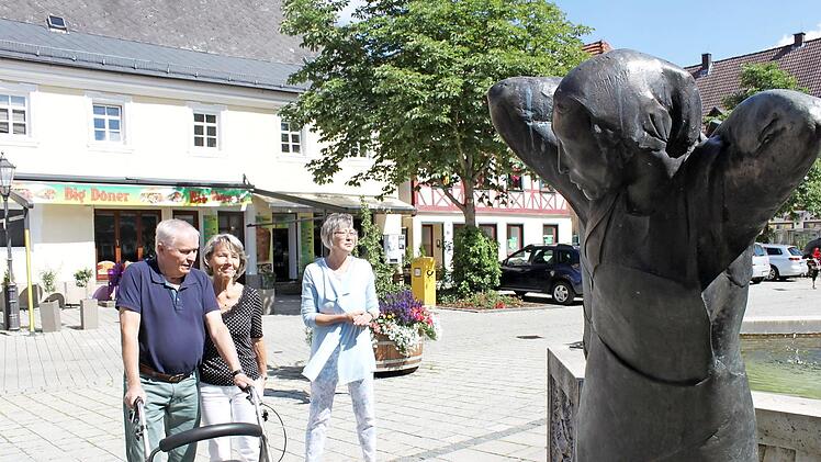 Gerhard und Ilse Schmidt machen mit Angela Theiler (r.) Halt am Brunnen am Ebermannstadter Marktplatz.  Foto: Carmen Schwind