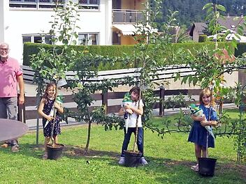 Maxi (ab Dritte von links), Lena und Margarete freuen sich mit (von links) Zweitem Bürgermeister Gerhard Eidelloth sowie den Gartenbauvereinsvorsitzenden Peter Mastalerz und Klaus Sesselmann (rechts) über ihre Schulbäume. Foto: Heike Schülein