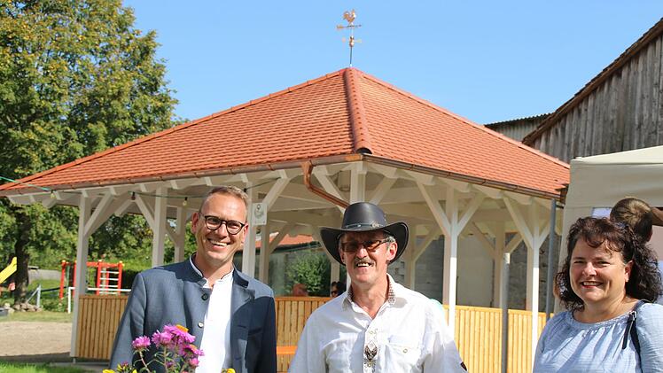 Bürgermeister  Mario Götz, Ortssprecher Paul Bieber und Allianzmanagerin Kissinger Bogen, Stephanie Kunder, vor dem neuen Pavillon im alten Schulgarten bei der Eröffnung.                Im Anschluss fand ein kleines fest statt. Foto: Hilmar Ruppert