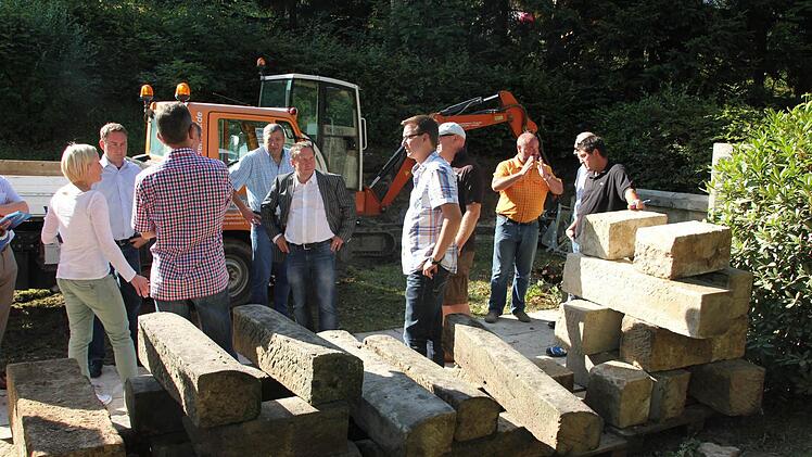 Im Friedhof Unterrodach wird ein kreisrundes Urnengräberfeld geschaffen. Doch zuvor ist eine Stützmauersanierung erforderlich. Die Steine im Vordergrund werden wieder in der Mauer verbaut. Darüber informierte Bürgermeister Norbert Gräbner den Marktgemeinderat bei einer Besichtigungstour.