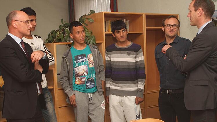 Landrat Wilhelm Schneider (links) und Bürgermeister Michael Ziegler sowie Betreuer Peter Rödelmaier (von rechts) im Gespräch mit den gerade angekommenen Jugendlichen