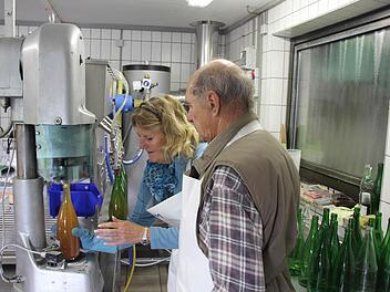 Ursula Meinhardt und Hermann Schneider an der neuen Abfüllmaschine. Die Verschlussmaschine (vorne links) befestigt die neuen Schraubverschlüsse auf den Flaschen. Fotos: F. Schedel