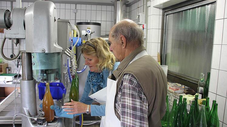 Ursula Meinhardt und Hermann Schneider an der neuen Abfüllmaschine. Die Verschlussmaschine (vorne links) befestigt die neuen Schraubverschlüsse auf den Flaschen. Fotos: F. Schedel