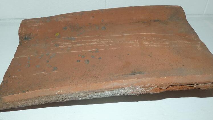 Der Dachziegel aus dem Jahr 1660 ist das neueste - und auch gleich mit älteste - Ausstellungsstück im Friedensmuseum Meeder. Foto: Karin Günther