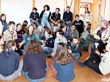 Im großen Versammlungsraum sitzen die Pfadfinder der drei Bünde - noch in verschiedenen Kluften - zusammen.  Foto: Johanna Blum