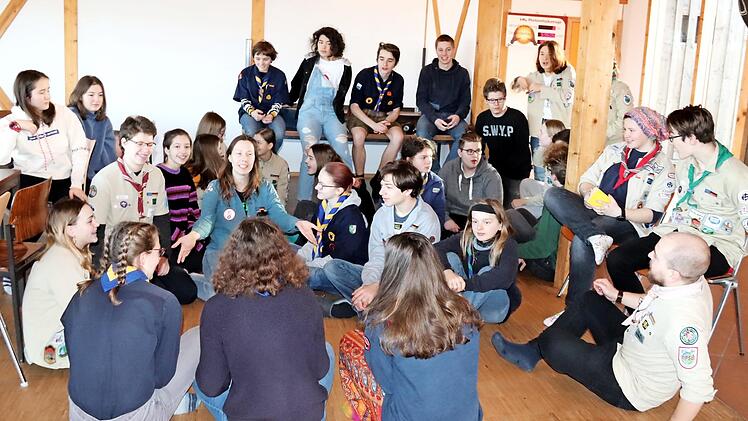 Im großen Versammlungsraum sitzen die Pfadfinder der drei Bünde - noch in verschiedenen Kluften - zusammen.  Foto: Johanna Blum