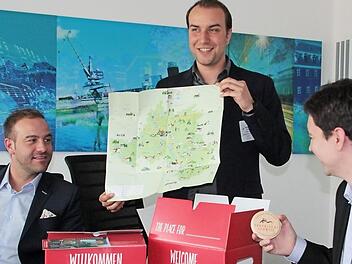 Auch Bierdeckel und Wanderkarte gehören zum wegweisenden Willkommenspaket, das (v.l.) Maximilian Streit, Leiter des Bereichs Healthcare der Firma Hegele, WIR-Regionalmanager Tobias Alt und Wirtschaftsförderer Viktor Naumann präsentieren.  Foto: Andreas Oswald