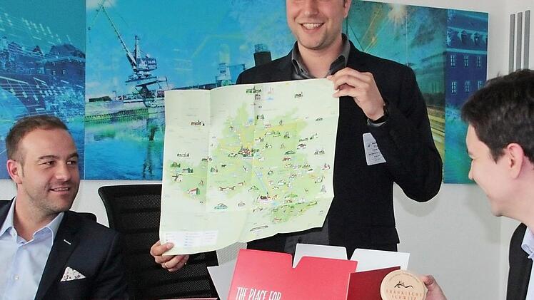 Auch Bierdeckel und Wanderkarte gehören zum wegweisenden Willkommenspaket, das (v.l.) Maximilian Streit, Leiter des Bereichs Healthcare der Firma Hegele, WIR-Regionalmanager Tobias Alt und Wirtschaftsförderer Viktor Naumann präsentieren.  Foto: Andreas Oswald