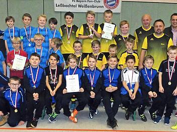 Ein spannendes E-Junioren Hallenfußball-Turnier wurde beim FC Bayern Fanclub Leßbachtal Weißenbrunn geboten. Im Bild (vorne) die Sieger vom FSV Ziegelerden, dahinter (rechts) der SV Steinwiesen und der ATSV Thonberg, sowie (von links) die Turnierleitung mit Bernd Brünnecke, Peter Ramer, Thilo Degenbeck und (von rechts) die Schiedsrichter Ali Duman und Marco Mäder, Vorsitzende Petra Jörg und Schirmherr Jörg Neubauer.  Fotos: Dieter Wolf