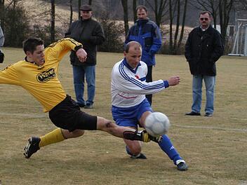 Unser Archivbild vom 8. März 2003 zeigt eine riskante Grätsche von Thulbas Frank Gerlach (links) gegen den Bad Kissinger Spielertrainer Martin Halbig. Klar, dass es in diesem Bezirksliga-Derby ordentlich zur Sache ging. Foto: Hopf