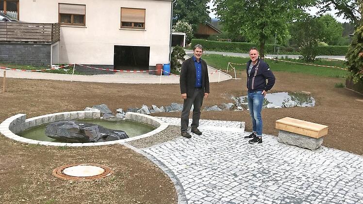 Birnbaum unterer Platz: Erster Bürgermeister Gerhard Wunder (l.) und Zweiter Bürgermeister Frank Hauck überzeugen sich von den gelungenen Arbeiten in der kleinen Parkanlage in Birnbaum. Foto: Gemeinde Steinwiesen