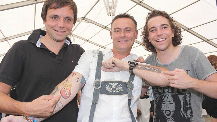 Da staunen sogar die Dorfrocker Markus (links) und Philipp, denn Fan Thomas Knörlein aus Gößweinstein hat sich bereits zwei Tattoos stechen lassen. "Von der ersten Stunde an war ich immer dabei", so der 45-jährige.