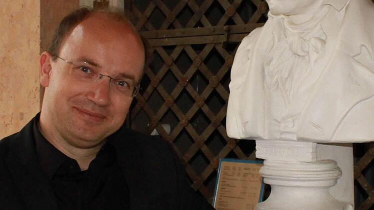 Roland Kluttig neben der Beethoven-Büste im Spiegelsaal des Coburger Landestheater.Foto: Jochen Berger