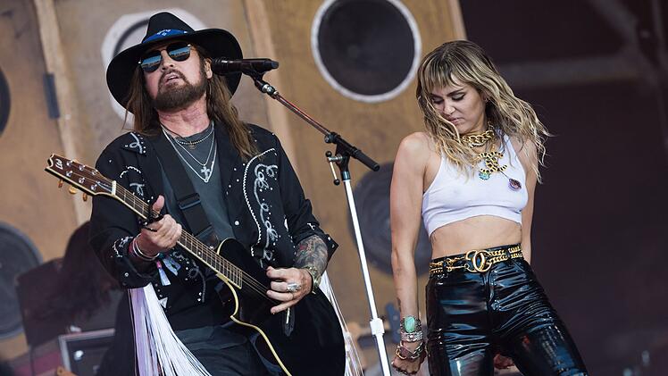 Miley Cyrus versuchte lange Zeit, ihr Image als Disney-Kinderstar mit aller Gewalt abzuschütteln. Inzwischen ist sie einer der größten Popstars der Gegenwart. Hier tritt die Sängerin gemeinsam mit Papa Billy Ray Cyrus auf dem Glastonbury-Festival 2019 auf.