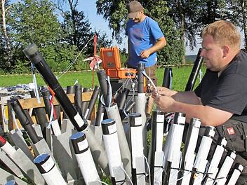 Florian Schneider (vorne) und Sascha Bald schließen die Zündschnüre an die Feuerwerksbomben an.  Fotos: Andreas Schmitt