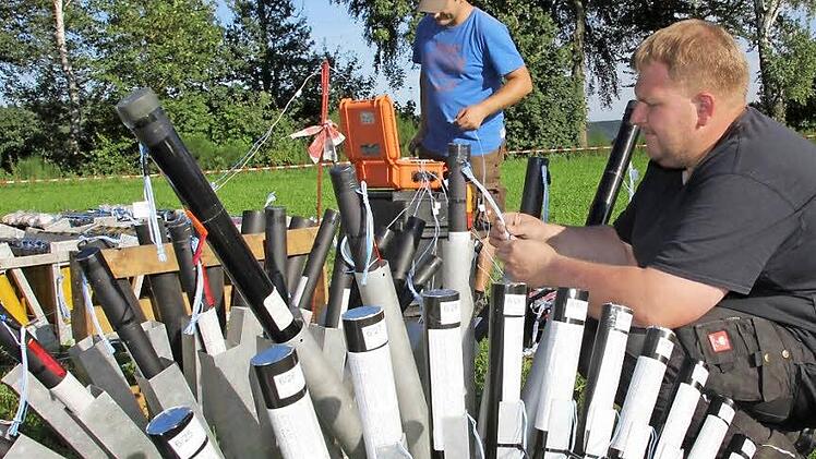 Florian Schneider (vorne) und Sascha Bald schließen die Zündschnüre an die Feuerwerksbomben an.  Fotos: Andreas Schmitt