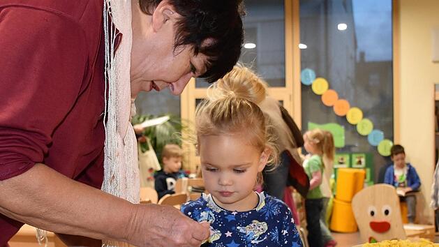 Petra Raupach hilft der kleinen Nelli mit der richtigen Menge an Joghurt.  Diakonisches Werk/Ute Nickel