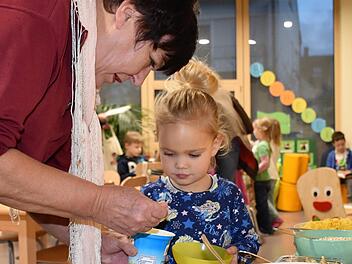 Petra Raupach hilft der kleinen Nelli mit der richtigen Menge an Joghurt.  Diakonisches Werk/Ute Nickel