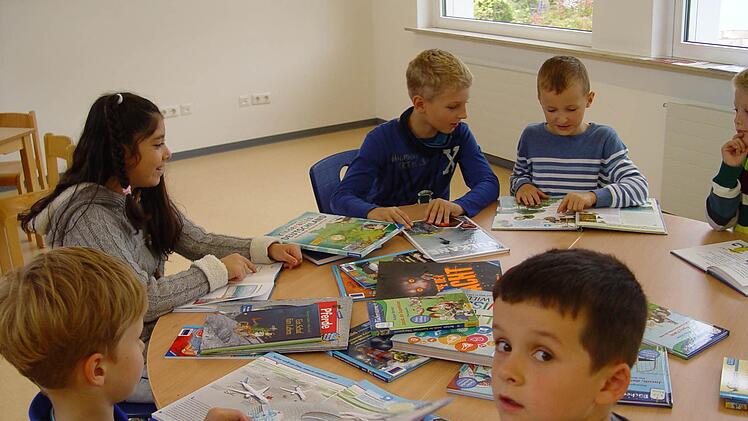 Miteinander am Tisch und die Bücher aus der Kiste. Foto: Brigitta Kempe-Wolf