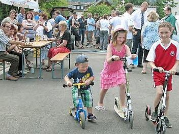 Während Anlieger und Gäste beim Straßenfest den Abschluss der Bauarbeiten feierten, testeten Robert, Selin und Noah mit ihren Tretrollern den jetzt glatten Straßenbelag der Forststraße. Foto: Klaus Oelzner