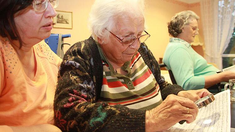 Das Lesen der Gleichmann-Handschriften erfordert gute Sütterlin-Kenntnisse, Geduld und oft auch den Einsatz der Lupe. Berta Focke (94), hier mit Betreuungskraft Karin Friedmann (links) und Käthe Hohner (82), kann fast alles entziffern. Foto: Dagmar Besand