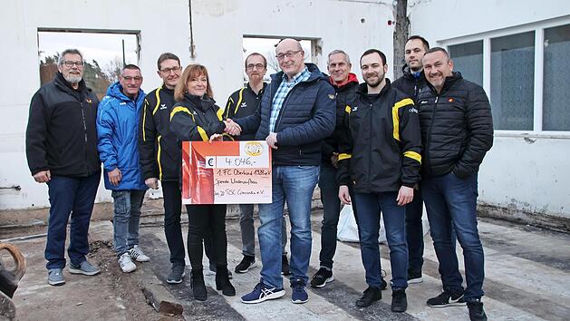 Das Vorstandsteam des RSC Oberhaids hat dem FC Oberhaid einen symbolischen Scheck im abgebrannten Saal des Vereinsheims &uuml;bergeben.