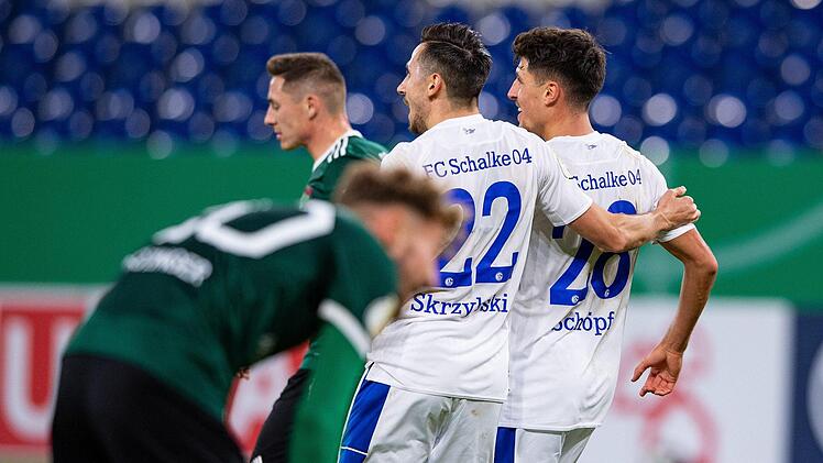 Schalkes Alessandro Schöpf (rechts) bejubelt eines seiner beiden Tore mit Steven Skrzybski. Ungachtet der Niederlage boten die viertklassigen Schweinfurter aber eine starke Leistung. Foto: Guido Kirchner/dpa
