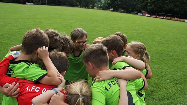 Auf geht's Zeil! Die Spieler und Spielerinnen der F-Jugend bilden einen Kreis und schw&ouml;ren sich auf das Spiel ein. Sie rufen im Chor: "Eins, zwei, drei, vier! Dieses Spiel gewinnen wir! F&uuml;nf, sechs, sieben, acht! Die Gegner werden platt gemacht!"  Fotos: Andreas L&ouml;sch