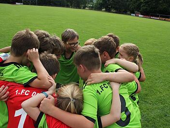 Auf geht's Zeil! Die Spieler und Spielerinnen der F-Jugend bilden einen Kreis und schwören sich auf das Spiel ein. Sie rufen im Chor: "Eins, zwei, drei, vier! Dieses Spiel gewinnen wir! Fünf, sechs, sieben, acht! Die Gegner werden platt gemacht!"  Fotos: Andreas Lösch