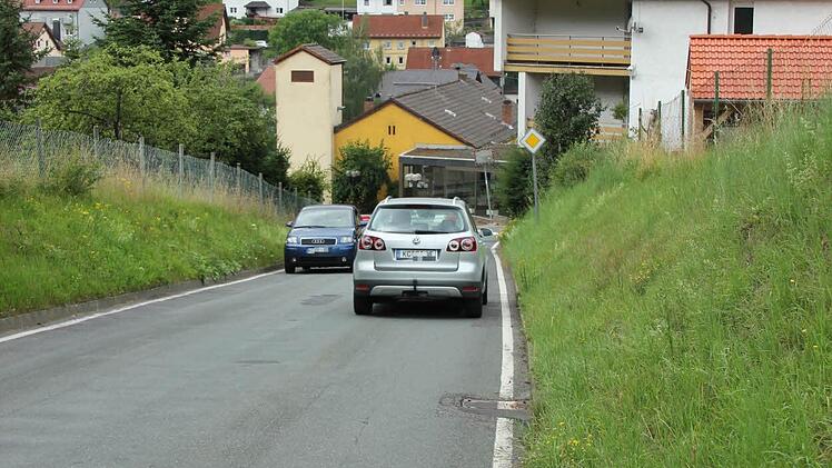 Die Kreisstraße 28 in Steinberg mit Rathaus (gelbes Gebäude) und den zwei Kirchen im Hintergrund  Foto: Friedwald Schedel