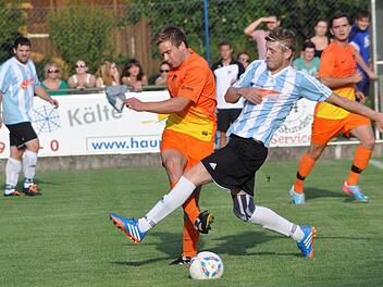 TSV Steinberg - FC Burggrub: Gästespieler Markus Wimmer (weiß-blaues Trikot) kommt einen Tick zu spät und kann nicht verhindern, dass Felix Müller den Ball zu einem Mannschaftskameraden weiterspielt. Foto: Herbert Kalb