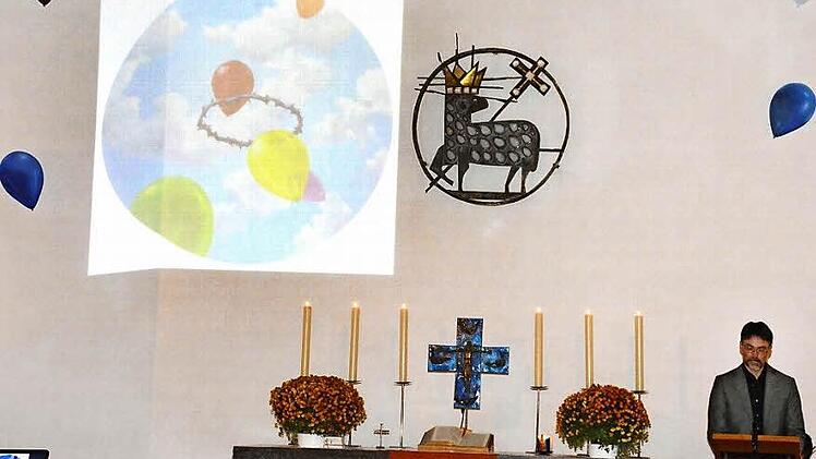 Das an die Wand projezierte Bild von den Luftballons und der Dornenkrone löste erheblichen Widerstand in der Kirchengemeinde aus. Künstler Gerhard Rießbeck (rechts) versuchte, sein Werk nochmals zu erklären.Foto: Gerhard Schmidt