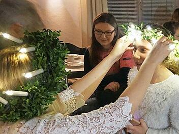 "Luzia" Eva Kefes setzte den Kindern Leucht-Kr&auml;nze auf. Foto: Prei&szlig;inger