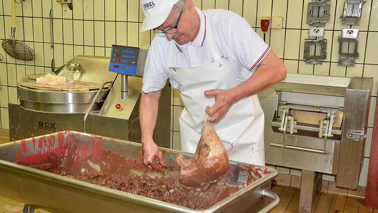 Die Masse für den Rotgelegten füllt Metzgermeister Raymund Kirchner per Hand in zuvor mehrfach gereinigte Schweinemägen ab. Foto: Kathrin Kupka-Hahn