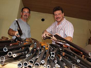 Frisch aus der Waffenkammer: Auf dem Tisch vor Ralf Karl und Gerhard Ackermann türmen sich die Gewehre für die Bürgerwehr. Genau einen Nachmittag haben die Waffen Ausgang, dann werden sie wieder für ein Jahr im Rathaus eingelagert.Foto: Nina Grötsch