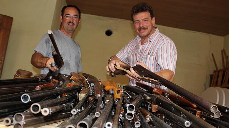 Frisch aus der Waffenkammer: Auf dem Tisch vor Ralf Karl und Gerhard Ackermann türmen sich die Gewehre für die Bürgerwehr. Genau einen Nachmittag haben die Waffen Ausgang, dann werden sie wieder für ein Jahr im Rathaus eingelagert.Foto: Nina Grötsch