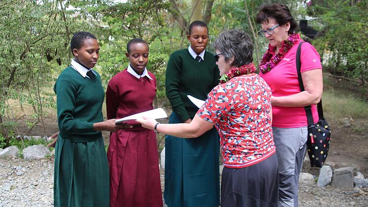 Auf dem Programm standen viele Schulbesuche. An der Ngarenanyuki Secondary School trafen die Gäste mit Deborah, Mary und Tumaini (von rechts) auf drei talentierte aber mittellose Schülerinnen, für deren Schulgebühren das Dekanat Michelau aufkommt. Waltraud Leppert (rechts) und Veronika Flierl überreichten ihnen Schreibmaterial. Foto: Manja von Nida