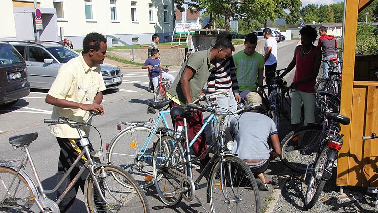 Die neuen Fahrräder der Postbediensteten waren bei den Asylbewerber begehrt und wurde gleich inspiziert. Foto: Ralf Kestel